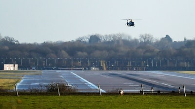 A police helicopter flies over the runway at Gatwick airport, London.
