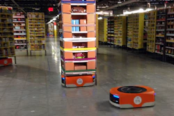 A robot moves under a stack of merchandise during a tour of an Amazon facility in Tracy, Calif., Nov. 30, 2014.
