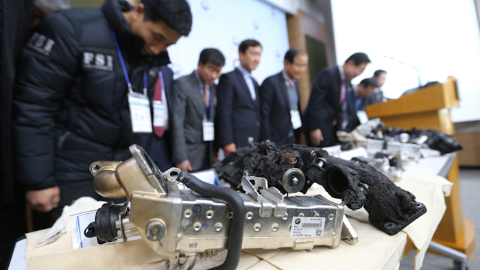 Transport Ministry officials and members of the investigative panel on BMW bow during a press conference in Seoul.