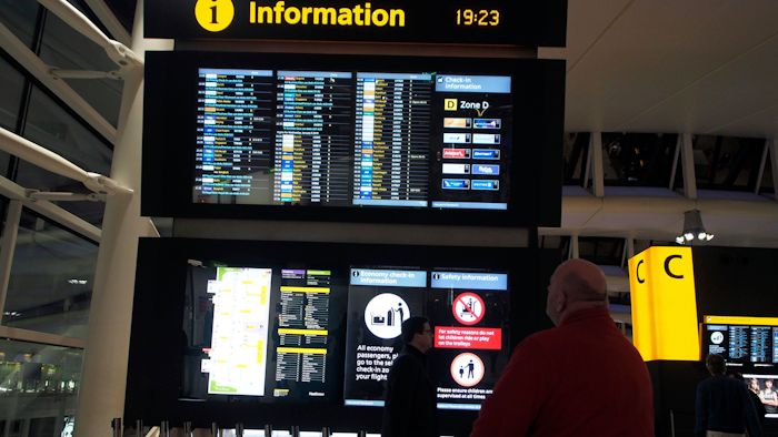 Passengers look at the departure board after planes were temporarily suspended at Heathrow Airport in London, Tuesday, Jan. 8, 2019.