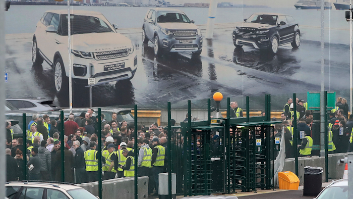 Staff gather inside the gates of the Jaguar Land Rover site in Halewood near Liverpool, England, Thursday Jan. 10, 2019.