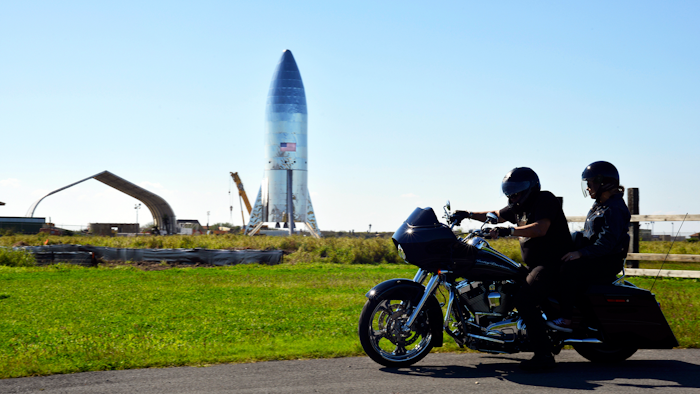 In this Jan. 12, 2019 file photo, a motorcyclist rides near the SpaceX prototype Starship hopper at the Boca Chica Beach site in Texas.