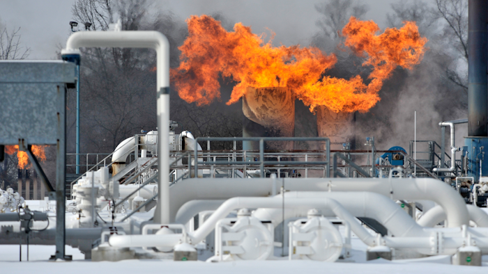 Fire comes out of the top of two structures at the compressor station at Consumers Energy in Armada Township, Mich.