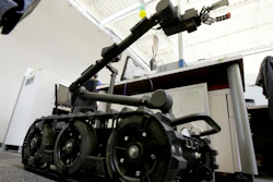 In this Aug. 28, 2018 photo a Centaur robot rests on a carpeted floor between desks at Endeavor Robotics in Chelmsford, Mass.