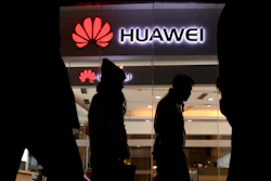 Pedestrians walk past a Huawei retail shop in Beijing Thursday, Dec. 6, 2018.