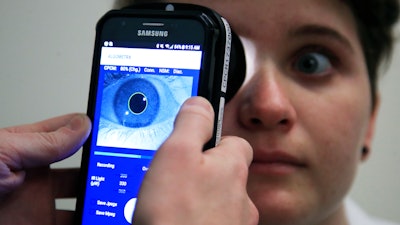 Clinical Research Assistant Kevin Jackson uses AlgometRx Platform Technology on Sarah Taylor's eyes at the Children's National Medical Center in Washington, Monday, Dec. 10, 2018.