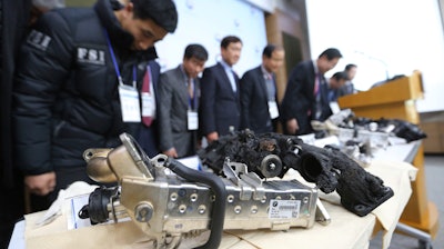Transport Ministry officials and members of the investigative panel on BMW bow during a press conference in Seoul.