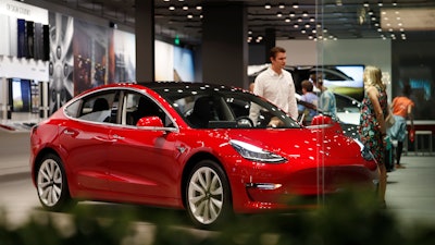 In this July 6, 2018, file photo, a Model 3 sits on display in a Tesla showroom in the Cherry Creek Mall in Denver.