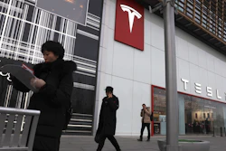 Residents walk past a Tesla store in Beijing, Monday, Jan. 7, 2019.