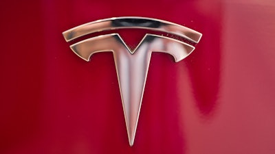 This Aug. 8, 2018, file photo shows a Tesla emblem on the back end of a Model S in the Tesla showroom in Santa Monica, Calif.