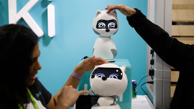 People touch Kiki robots at the Zoetic AI booth at CES International, Wednesday, Jan. 9, 2019, in Las Vegas.