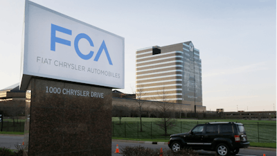 In this May 6, 2014, file photo, a vehicle moves past a sign outside Fiat Chrysler Automobiles world headquarters in Auburn Hills, Mich.