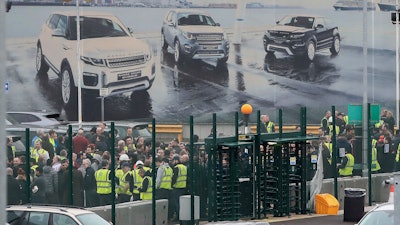 Staff gather inside the gates of the Jaguar Land Rover site in Halewood near Liverpool, England, Thursday Jan. 10, 2019.