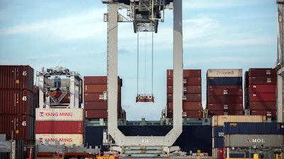 In this July, 5, 2018, file photo, a ship to shore crane prepares to load a 40-foot shipping container onto a container ship in Savannah, Ga.