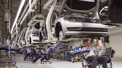 In this July 12, 2013, file photo, employees at the Volkswagen plant in Chattanooga, Tenn., work on the assembly of Passat sedans.