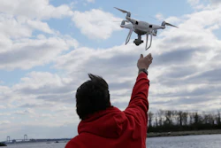 In this April 29, 2018, file photo, a drone operator helps to retrieve a drone after photographing over Hart Island in New York.