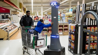 William Rucker and his grandson Justice, 4, say hello to a robot named Marty as it cleans the floors at a Giant grocery store in Harrisburg, Pa., Tuesday, Jan. 15, 2019.