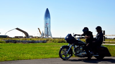 In this Jan. 12, 2019 file photo, a motorcyclist rides near the SpaceX prototype Starship hopper at the Boca Chica Beach site in Texas.