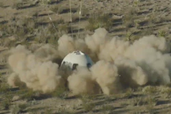 In this image from video made available by Blue Origin, the New Shepard capsule lands at the company's site in west Texas.