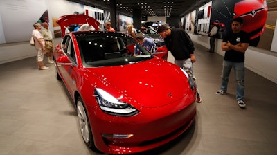 In this July 6, 2018, file photo, a Model 3 sits on display in a Tesla showroom in the Cherry Creek Mall in Denver.