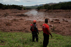 Civil firefighters survey a destroyed rail bridge two days after a dam collapse in Brumadinho, Brazil, Sunday, Jan. 27, 2019.