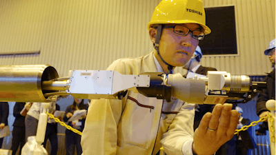 Toshiba Corp.'s energy systems unit group manager Jun Suzuki shows a remote-controlled melted fuel probe device at its facility in Yokohama, Monday, Jan. 28, 2019.