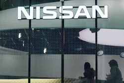 In this Nov. 22, 2018, file photo, visitors walk near the logo of Nissan at a showroom in Tokyo.