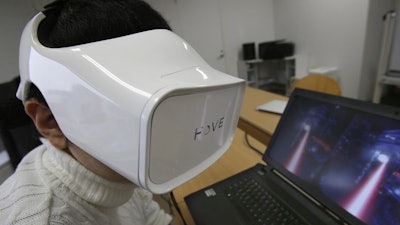 In this March 7, 2016 photo, Fove staff demonstrates virtual reality at an office in Tokyo.