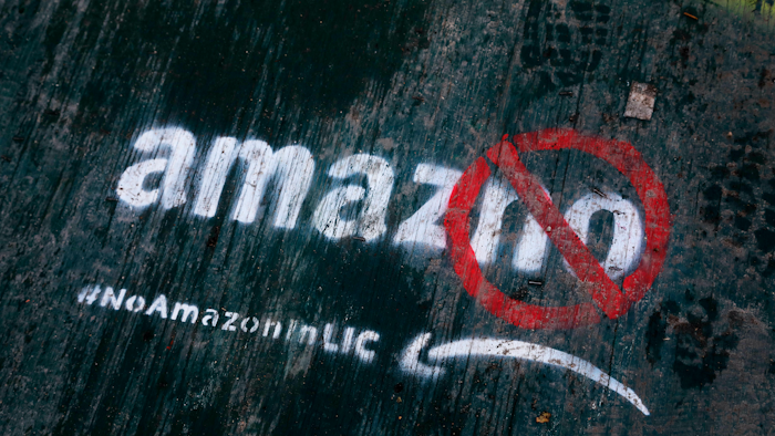 In this Nov. 16, 2018, file photo, graffiti painted on a sidewalk opposes the location of an Amazon headquarters in Long Island City.