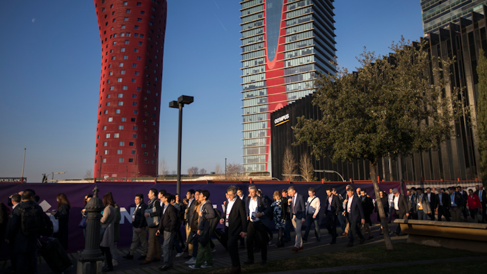 Attendees walk to enter the Mobile World Congress wireless show in Barcelona, Monday, Feb. 25, 2019.
