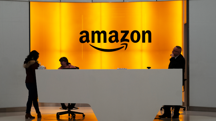 In this Feb. 14, 2019, file photo, people stand in the lobby for Amazon offices in New York.