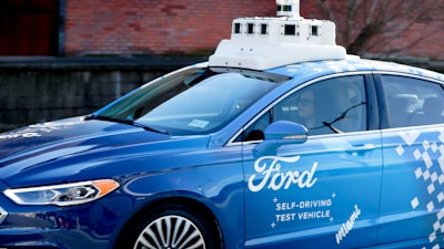 In this Dec. 18, 2018, photo, one of the test vehicles from Argo AI, Ford's autonomous vehicle unit, navigates near the company offices in Pittsburgh.