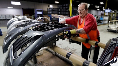 This Wednesday, Nov. 28, 2018, file photo shows Clifford Goff, a bezel assembler, transferring a front end of a Chevrolet Cruze during assembly at Jamestown Industries in Youngstown, Ohio.
