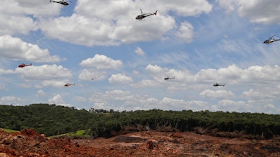 Helicopters release flower petals paying homage to victims killed after a mining dam collapsed in Brumadinho, Brazil, Friday, Feb. 1, 2019.