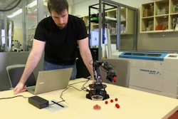 In this image made from a Feb. 1, 2019, video, Robert Kwiatkowski, a graduate student at Columbia University, demonstrates a robotic arm picking up a red ball and dropping it in a cup.