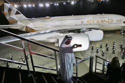 In this Dec. 18, 2014, file photo, a man takes a photo in front of a new Etihad Airways A380 in Abu Dhabi, United Arab Emirates.