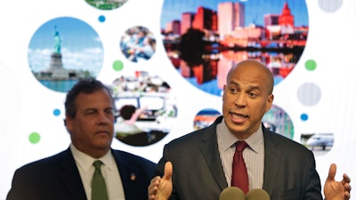 In this Oct. 16, 2017, file photo, New Jersey Sen. Cory Booker speaks while Gov. Chris Christie stands behind him during an announcement in Newark, N.J.