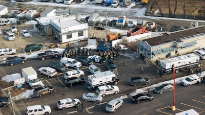 First responders and emergency vehicles are gathered near the scene of a shooting at an industrial park in Aurora, Ill., on Friday, Feb. 15, 2019.