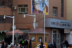 In this Nov. 5, 2017, file photo, residents pass by a security checkpoint and surveillance cameras mounted on a street in Kashgar in western China's Xinjiang region.