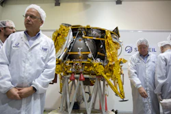 In this Monday, Dec. 17, 2018 file photo, technicians stand next to the SpaceIL lunar module in their facility near Tel Aviv, Israel.