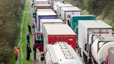 In this April 6, 2016, file photo, truck drivers stand among trucks on a highway in Spontin, Belgium.