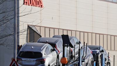 Cars leave the Honda factory in Swindon, England, Tuesday, Feb. 19, 2019.