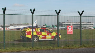 An emergency service vehicle by the perimeter fence after a confirmed drone sighting forced the temporary suspension of operations at Dublin Airport, Ireland, Thursday Feb. 21, 2019.