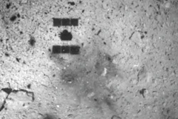 This image released by the Japan Aerospace Exploration Agency shows the shadow of the Hayabusa2 spacecraft after its successful touchdown on the asteroid Ryugu, Friday, Feb. 22, 2019.
