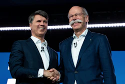 BMW CEO Harald Krueger, left, and Mercedes-Benz CEO Dieter Zetsche, right, shake hands at a press conference in Berlin, Friday, Feb. 22, 2019.