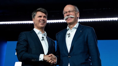 BMW CEO Harald Krueger, left, and Mercedes-Benz CEO Dieter Zetsche, right, shake hands at a press conference in Berlin, Friday, Feb. 22, 2019.