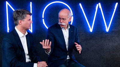In this Friday, Feb. 22, 2019, photo, Harald Krueger, left, CEO of BMW, and Dieter Zetsche, right, CEO of Mercedes-Benz, talk during a press conference in Berlin.