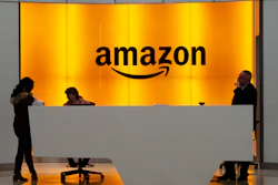 In this Feb. 14, 2019, file photo, people stand in the lobby for Amazon offices in New York.