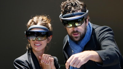 People use Microsoft Hololens to get an impression of Mercedes accessories during the International Frankfurt Motor Show IAA in Germany, Tuesday, Sept. 12, 2017.