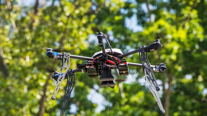 In this July 17, 2015, file photo, a Flirtey drone lowers a package of prescription medication at a clinic in Wise County, Va.